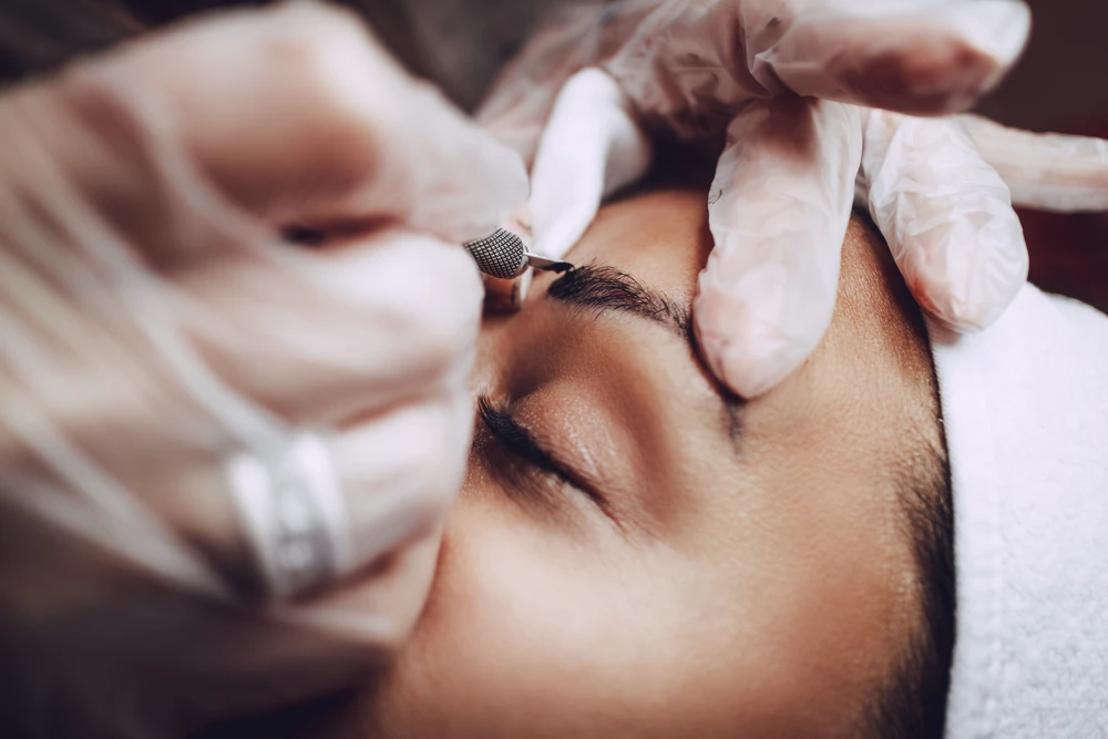 Microblading being performed on a woman's eyebrows
